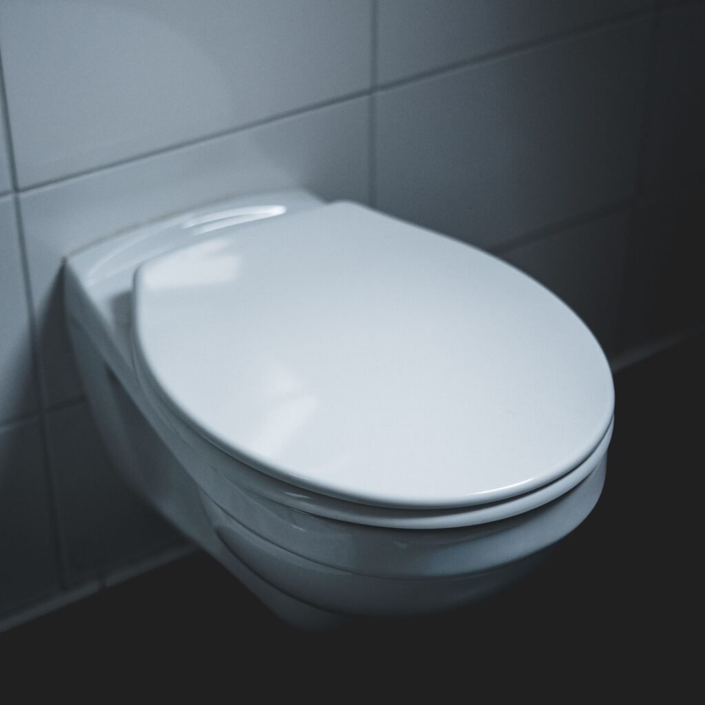 A sleek and modern white toilet in a well-lit minimalist bathroom setting.